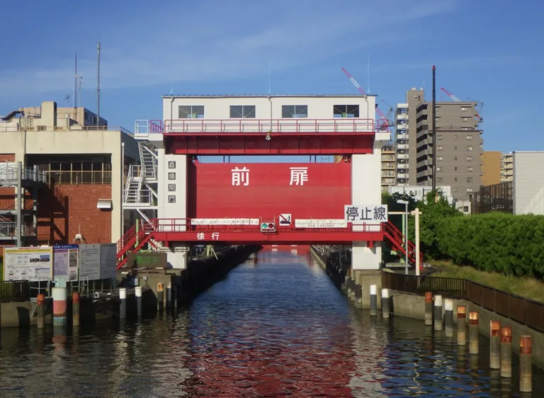 Transport bridge over a canal in an urban setting, facilitating boat passage while surrounded by modern buildings and greenery.