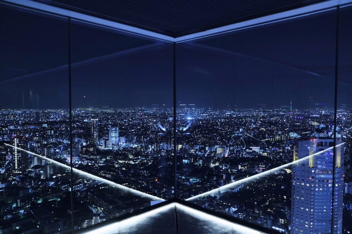 Stunning night view of a city skyline, illuminated by countless lights, showcasing urban beauty from a high vantage point.