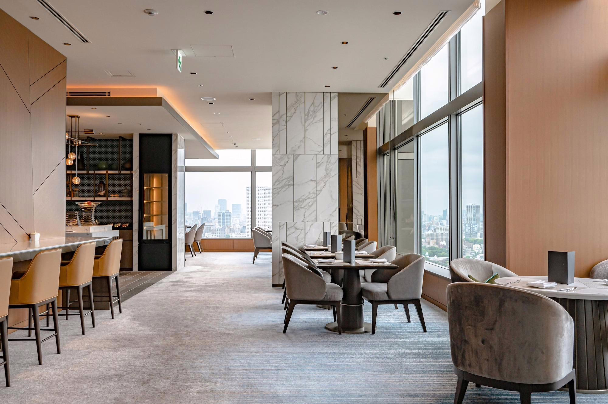 Elegant restaurant interior showcasing modern design, city skyline views, and sophisticated dining arrangements.