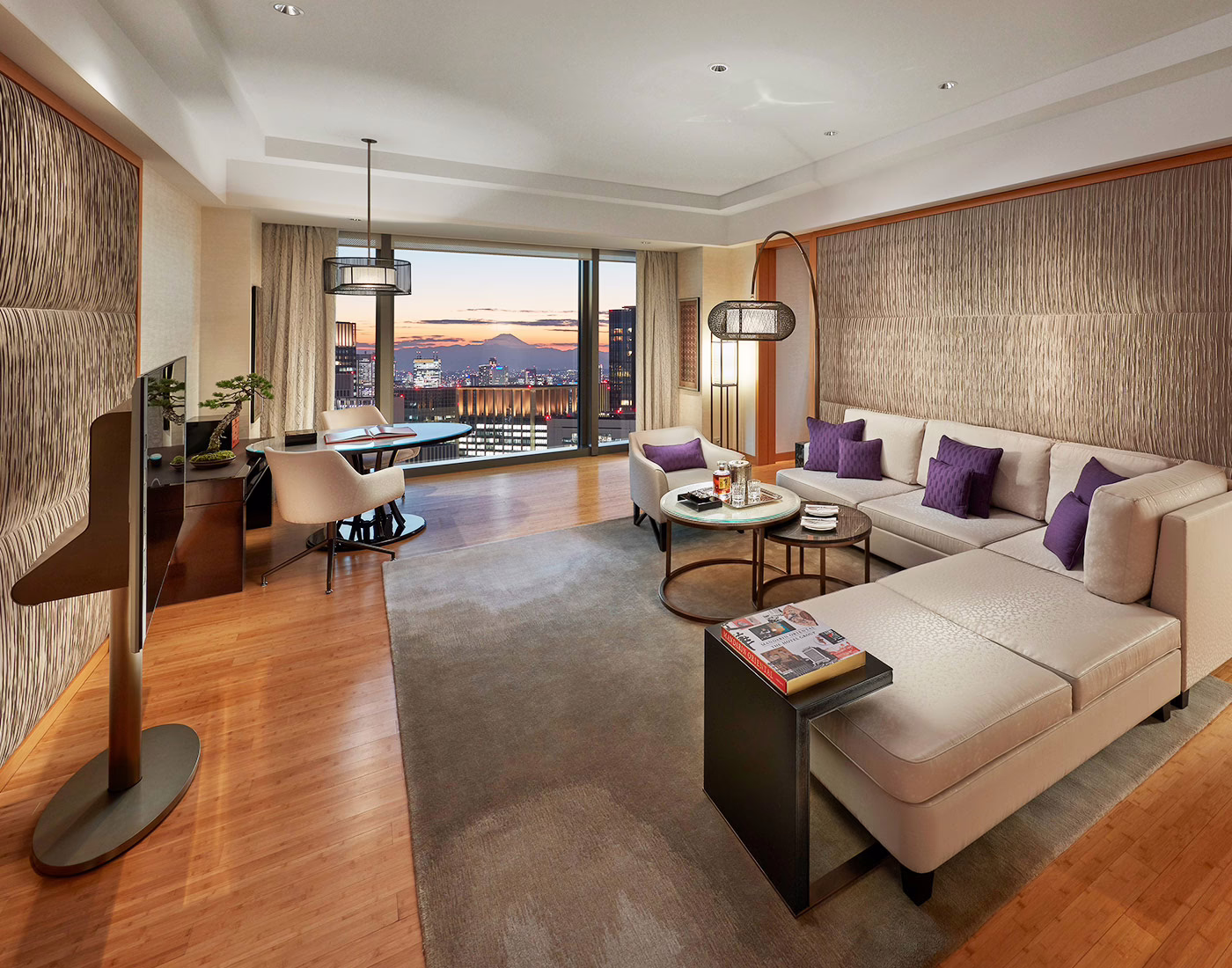 Luxurious hotel room with a stunning city view, featuring elegant furnishings and a peaceful atmosphere.