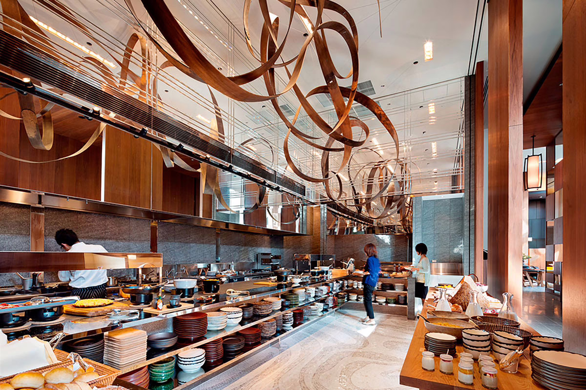 Contemporary buffet restaurant featuring sleek wooden decor and a variety of dishes on display for diners.