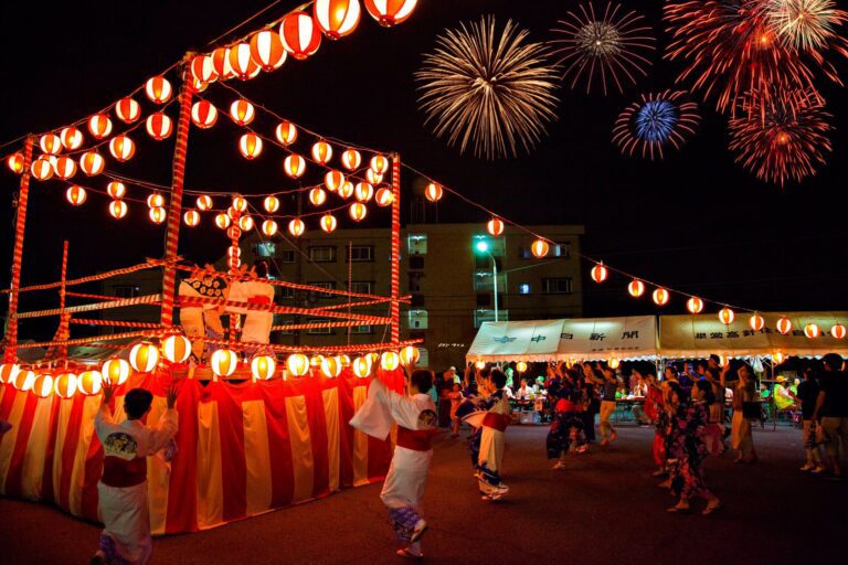 A vibrant summer festival scene with traditional dancers in yukatas celebrating under glowing lanterns and fireworks.