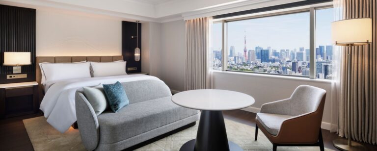 Stylish hotel room featuring a panoramic city view, plush bedding, and modern furnishings for a luxurious stay in Tokyo.