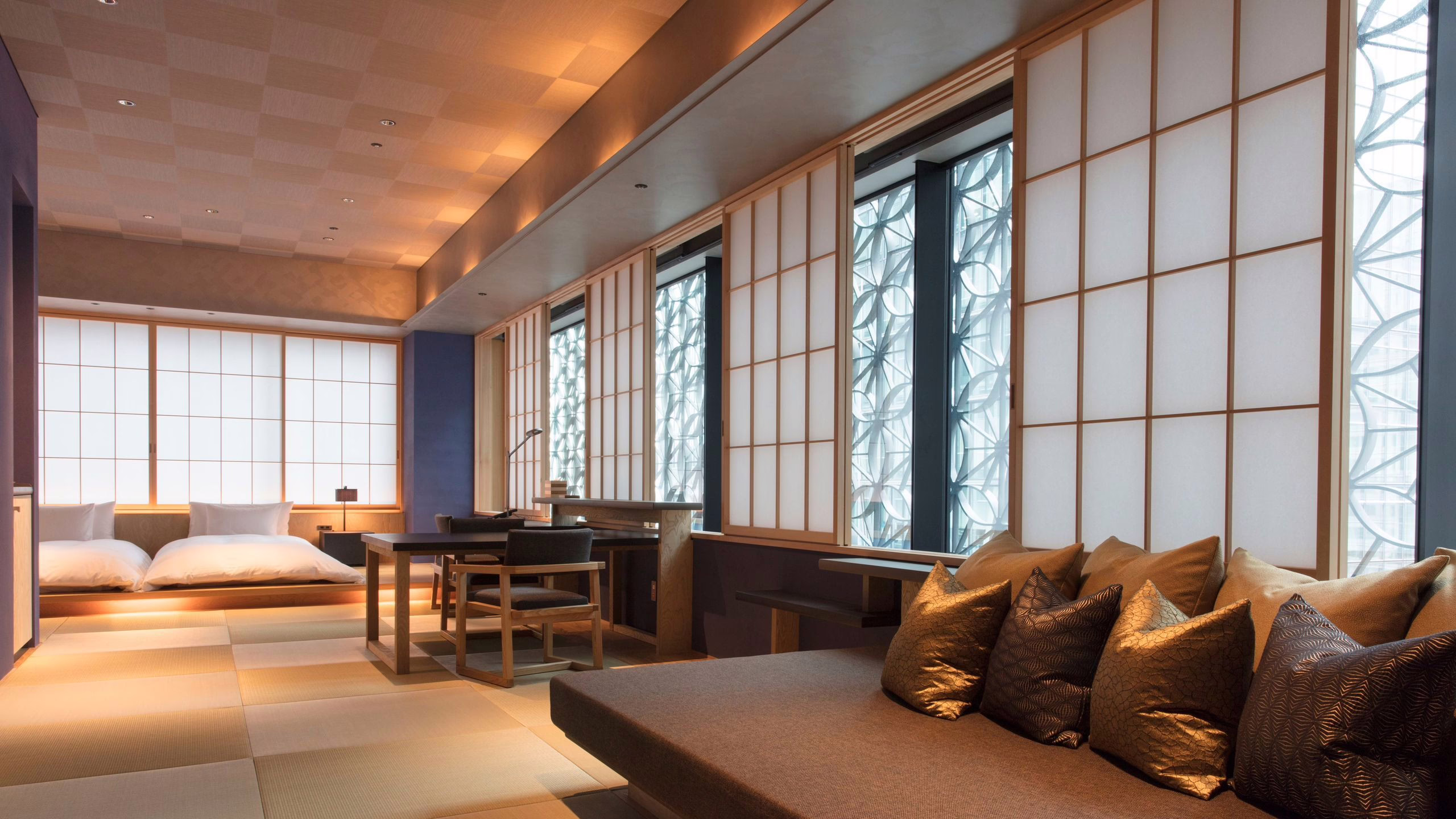 Modern Japanese-style hotel room featuring tatami flooring, elegant furnishings, and large windows for natural light.