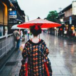 woman holding oil umbrella near on buildings