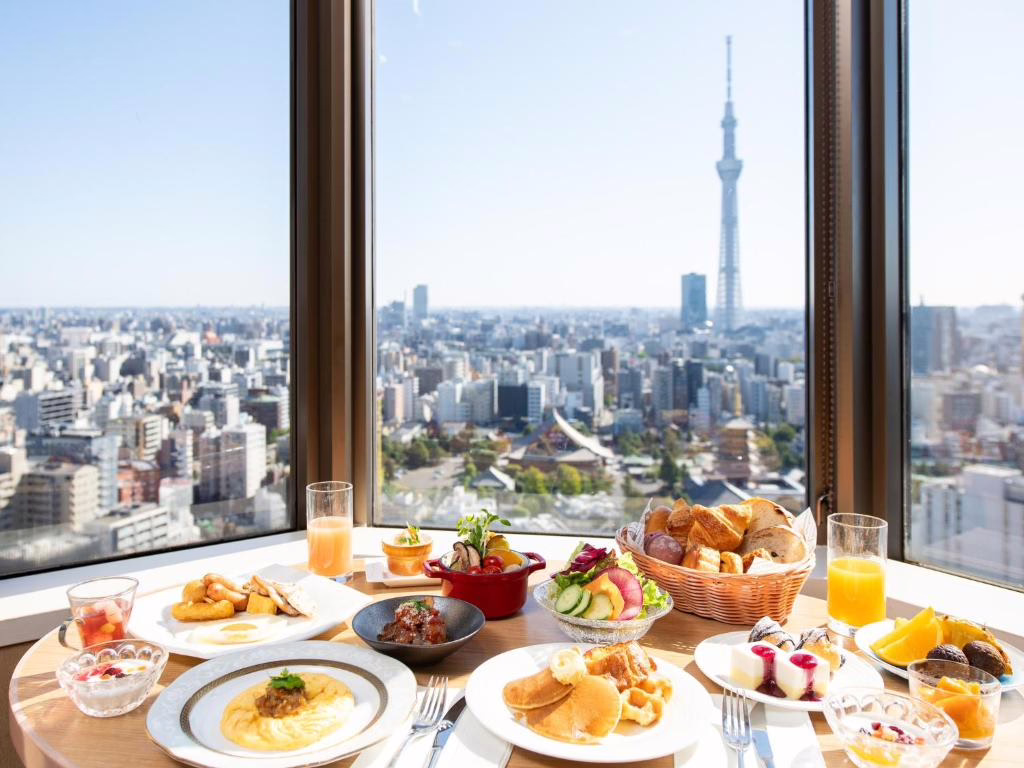 Luxurious breakfast spread with diverse dishes and Tokyo Skytree view, epitomizing fine dining experience in Japan.