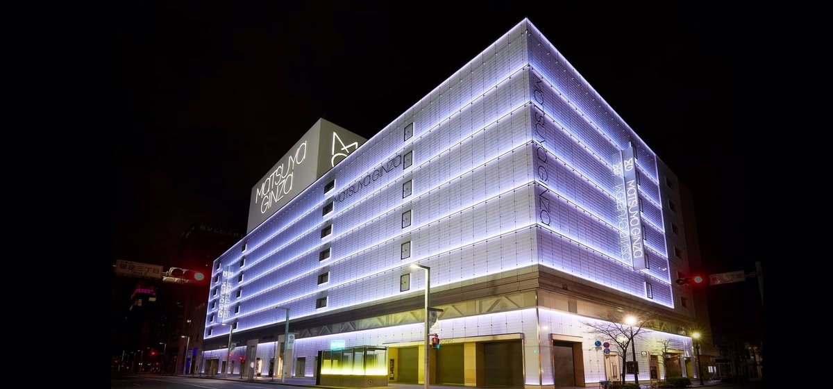 Modern department store in Ginza, illuminated at night with stylish architecture and vibrant lighting, attracting shoppers.