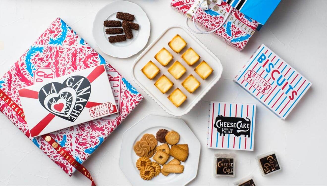 Assorted gourmet desserts featuring cheesecake squares, themed packaging, and an array of delightful biscuits for sharing.