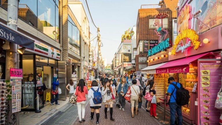 Vibrant shopping street in Takeshita Street Tokyo bustling with people exploring shops and enjoying street food delights.