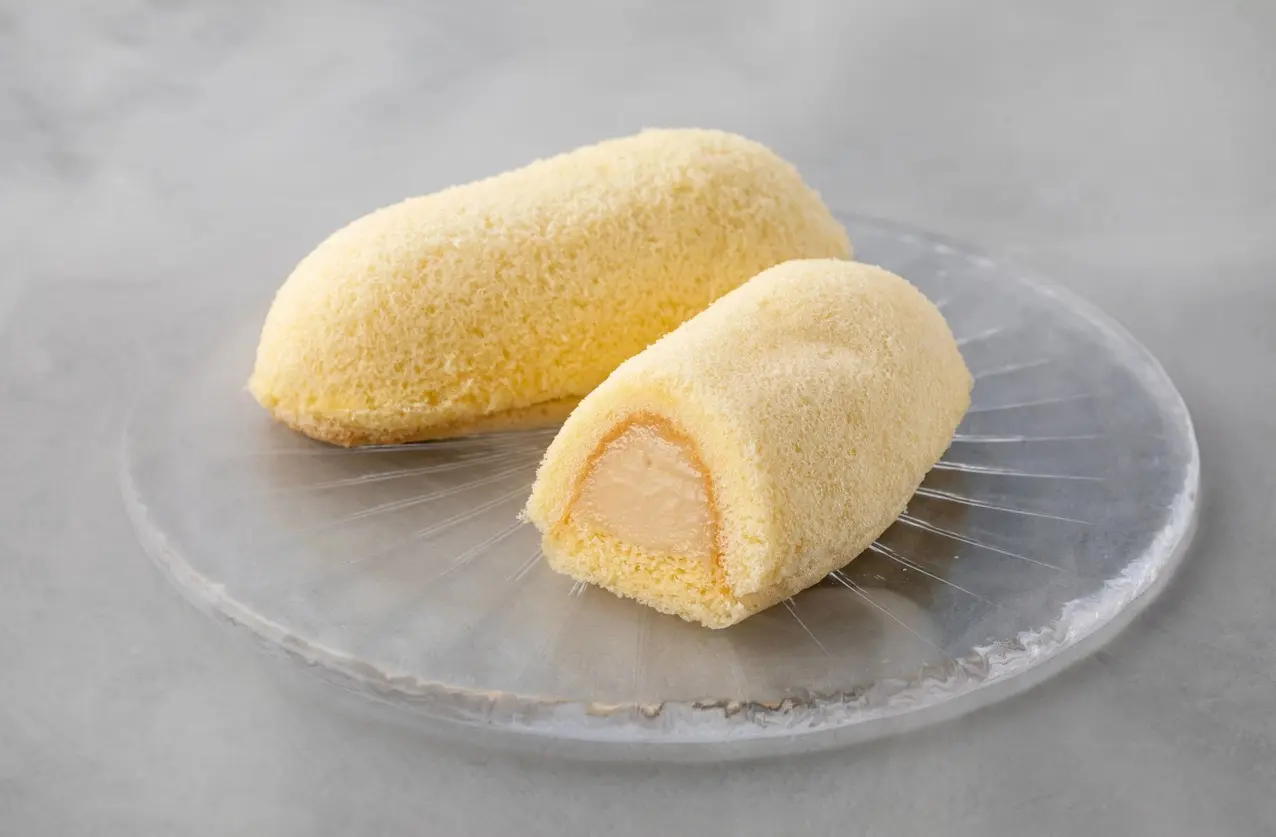 Creamy cake rolls filled with sweet custard, elegantly presented on a clear plate, perfect for dessert lovers.