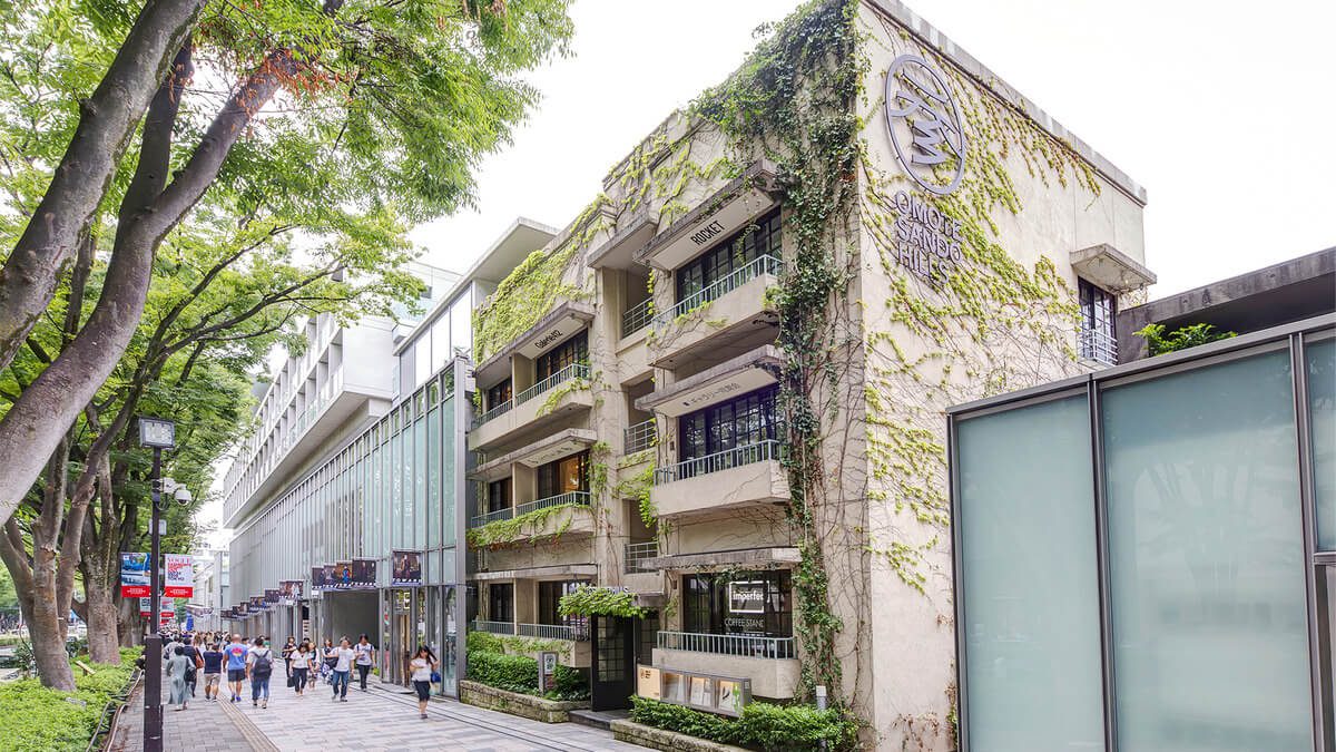 Stylish Omotesando Hills shopping area blends modern architecture with lush greenery, creating a vibrant urban atmosphere.