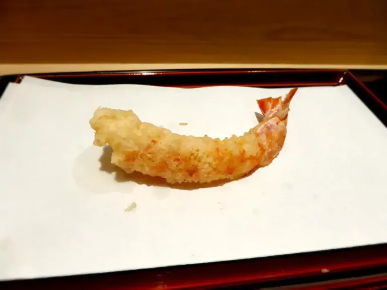 Crispy tempura shrimp served on a traditional plate, highlighting a popular Japanese dish enjoyed in sushi restaurants.